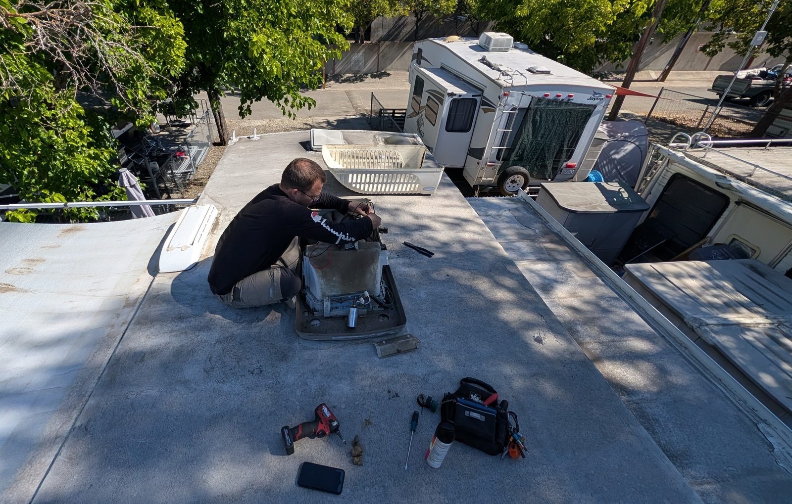 Mobile RV technician servicing a rooftop air conditioner