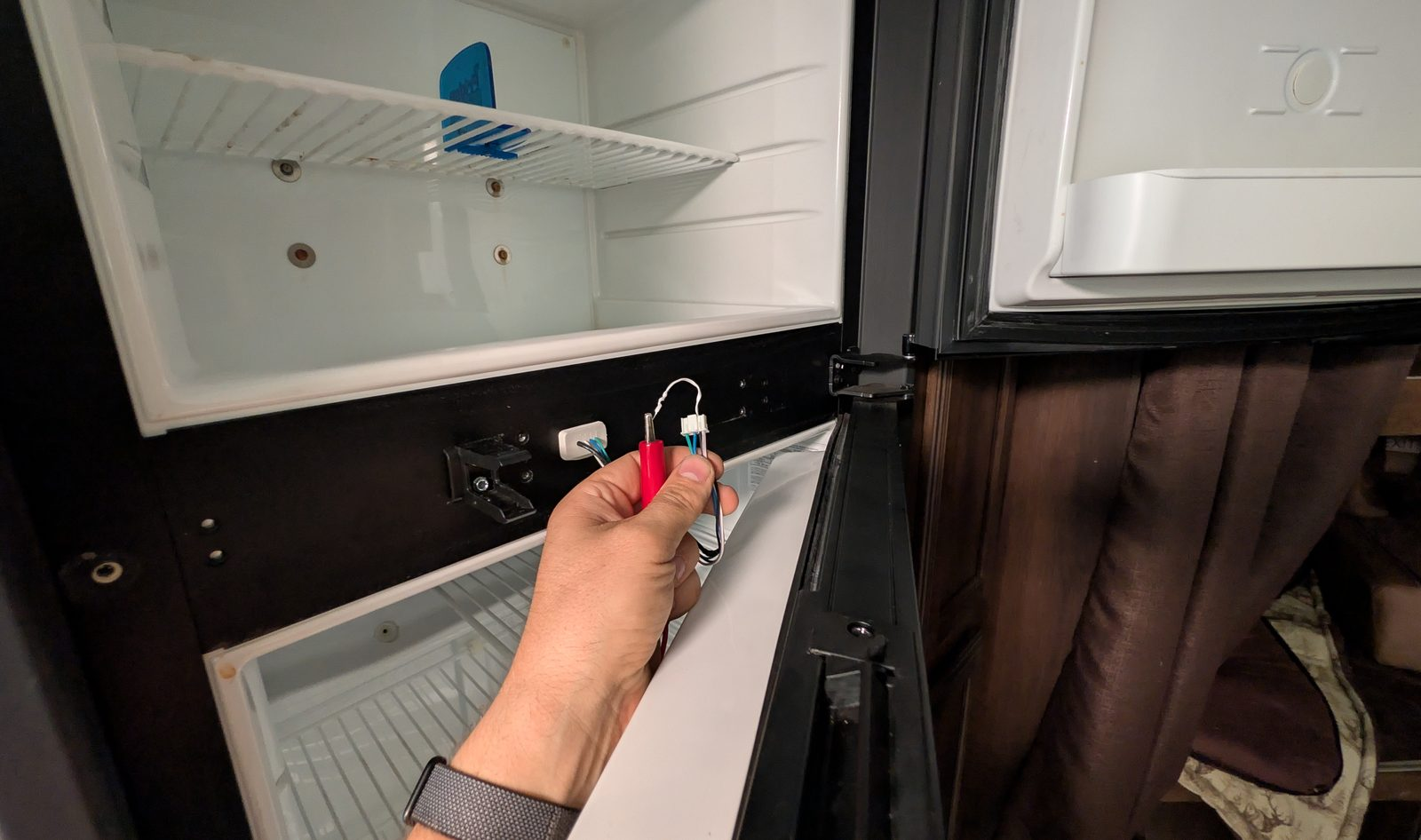 Technician testing an RV refrigerator component