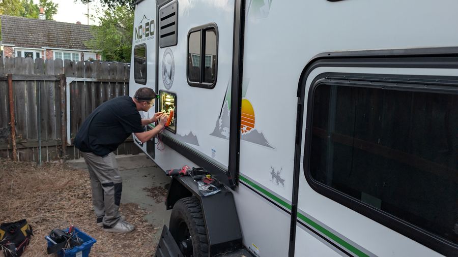 Technician repairing RV electrical system at customer location
