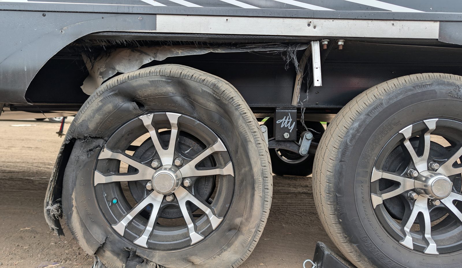 Towable RV wheel and suspension area inspected after tire damage