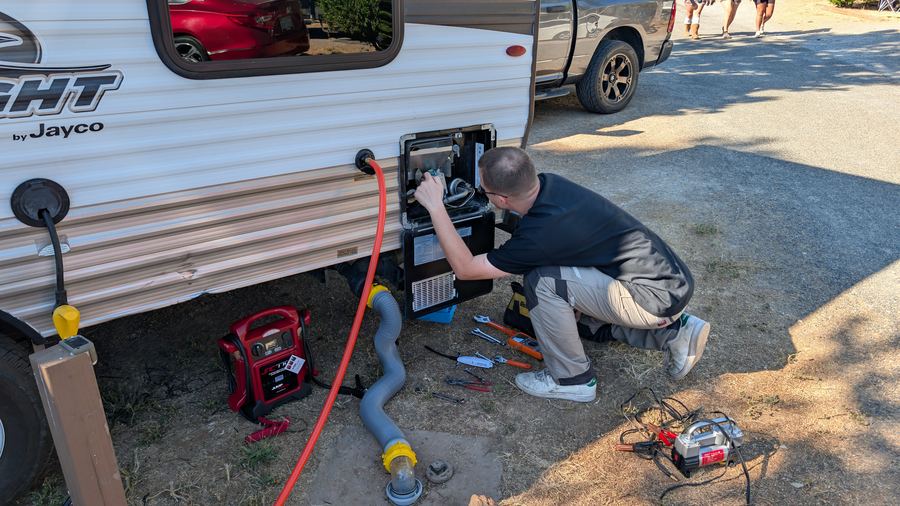 Technician servicing RV at campsite